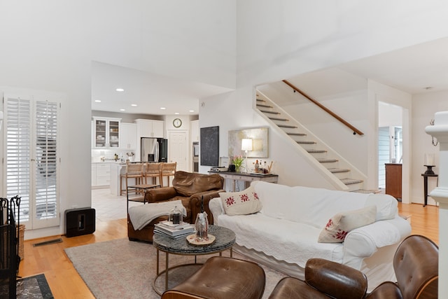 living room with light hardwood / wood-style flooring and a high ceiling