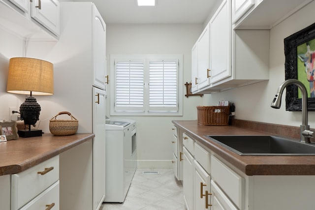 laundry room featuring cabinets, sink, and washing machine and dryer