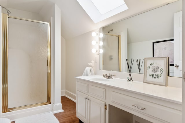 bathroom featuring a shower with door, lofted ceiling with skylight, wood-type flooring, and vanity