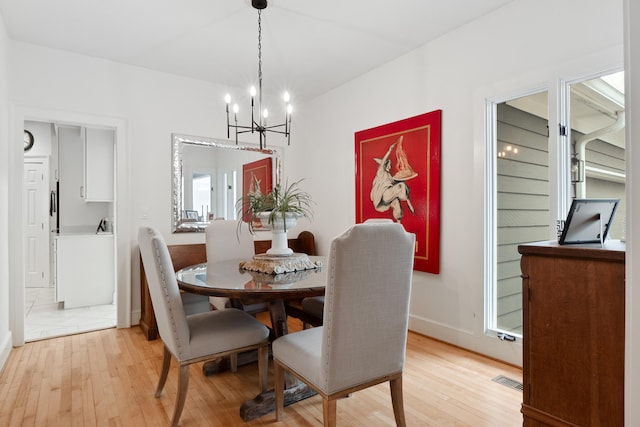 dining room with a notable chandelier and light wood-type flooring