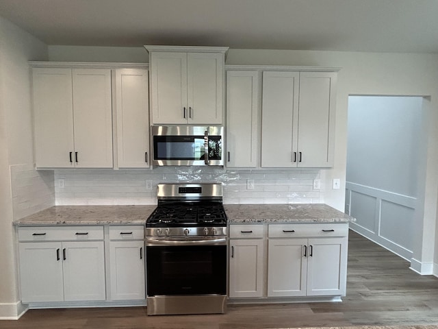 7553 Snow Cone Way Unit 17, Ooltewah, TN 37363 - kitchen with appliances with stainless steel finishes, light wood finished floors, white cabinetry, and tasteful backsplash