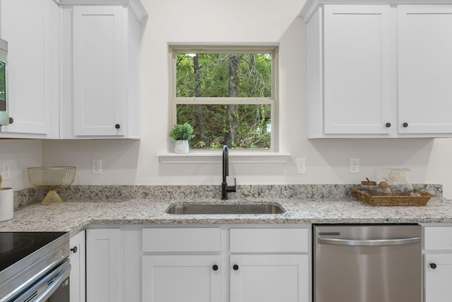 kitchen featuring sink, light stone counters, white cabinets, and appliances with stainless steel finishes