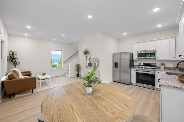 dining room with sink and light hardwood / wood-style flooring