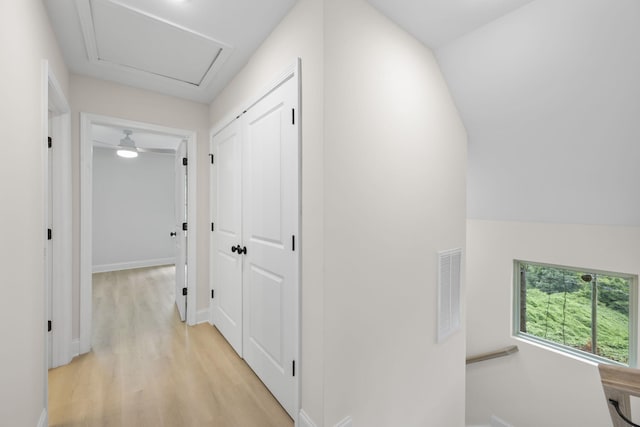 hall featuring vaulted ceiling and light hardwood / wood-style flooring