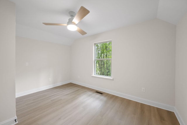 empty room with ceiling fan, light hardwood / wood-style floors, and lofted ceiling