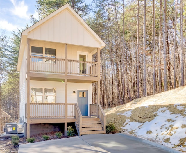 view of property with a balcony, cooling unit, and a porch