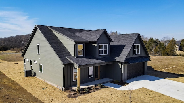 view of front of house with a garage and central AC