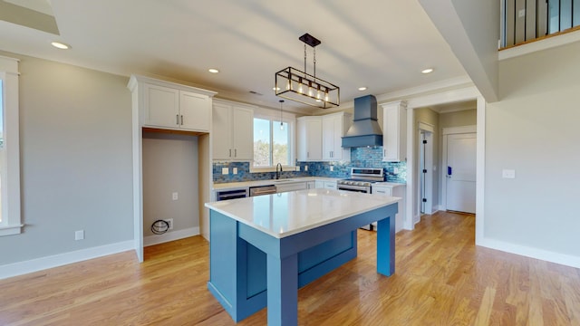 kitchen with white cabinetry, hanging light fixtures, stainless steel appliances, a kitchen island, and custom exhaust hood