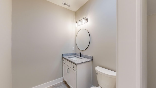 bathroom with vanity, hardwood / wood-style flooring, and toilet