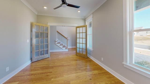 spare room with ornamental molding, ceiling fan, light wood-type flooring, and french doors