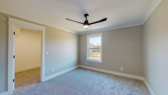 carpeted empty room with crown molding and ceiling fan