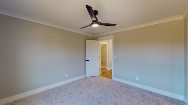 empty room featuring crown molding, ceiling fan, and light carpet