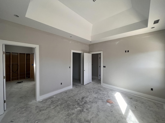 unfurnished bedroom featuring a raised ceiling