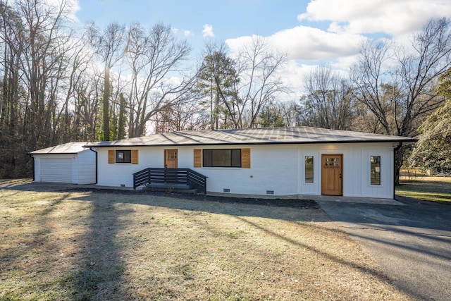 ranch-style home featuring a garage, an outdoor structure, and a front lawn