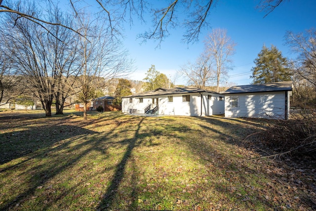 rear view of house featuring a lawn