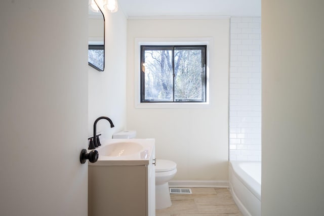 bathroom featuring vanity, a bath, tile patterned floors, and toilet