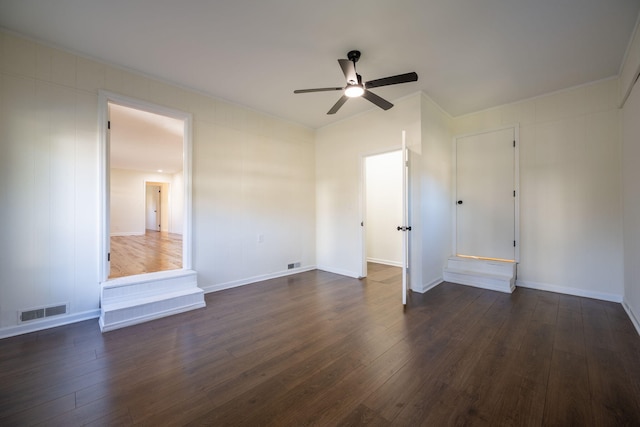 empty room with dark hardwood / wood-style floors and ceiling fan