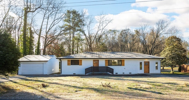 single story home with a garage, an outbuilding, and a front lawn