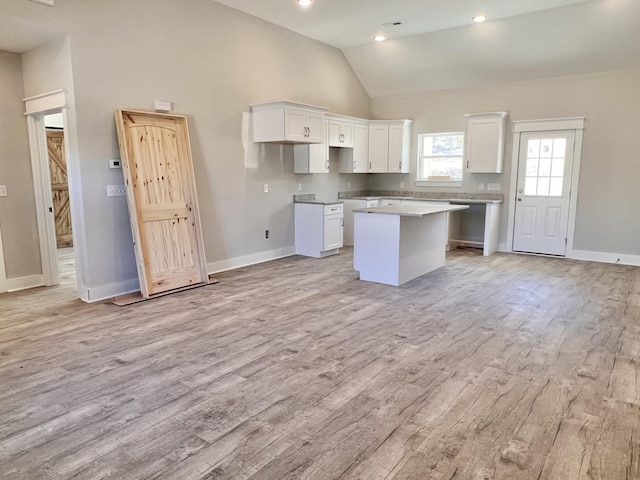 kitchen featuring white cabinetry, a kitchen island, and light wood finished floors