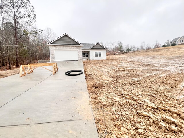 view of side of home featuring concrete driveway