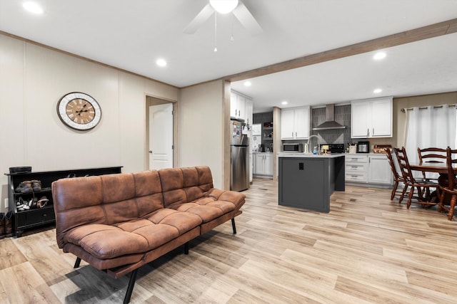 living room featuring ceiling fan, sink, and light hardwood / wood-style floors