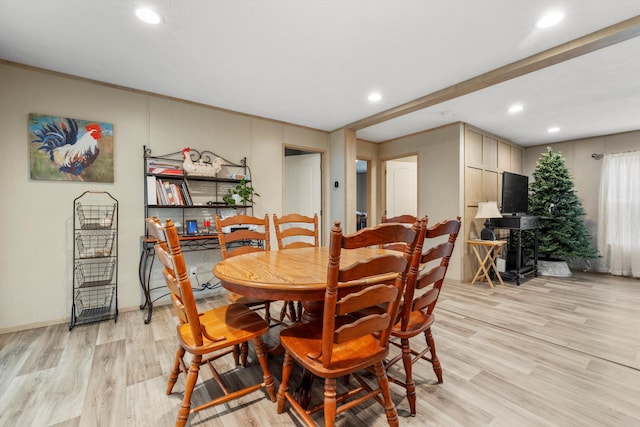 dining area featuring light hardwood / wood-style flooring and beamed ceiling