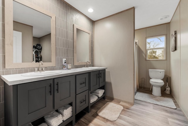 bathroom featuring hardwood / wood-style flooring, vanity, toilet, and tile walls