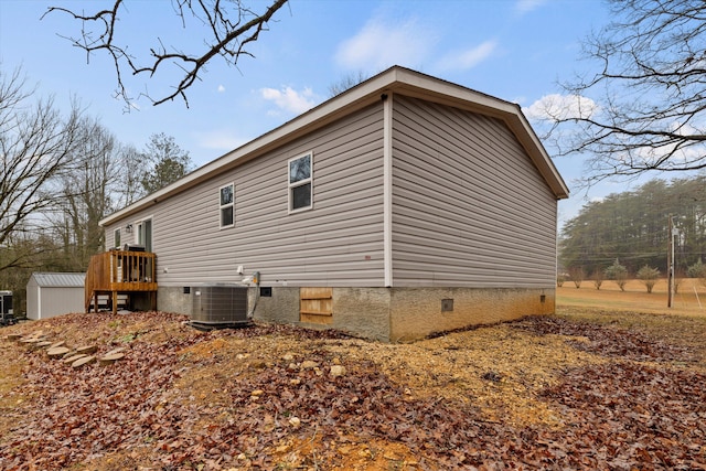 view of property exterior with cooling unit and a storage shed