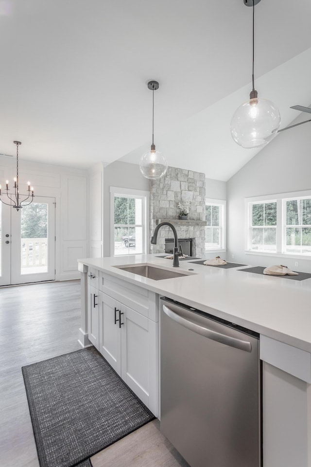 kitchen featuring pendant lighting, sink, stainless steel dishwasher, and white cabinets