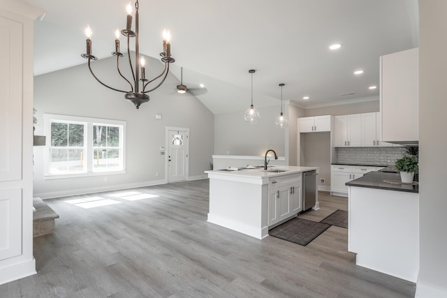 kitchen featuring decorative light fixtures, dishwasher, an island with sink, white cabinets, and decorative backsplash