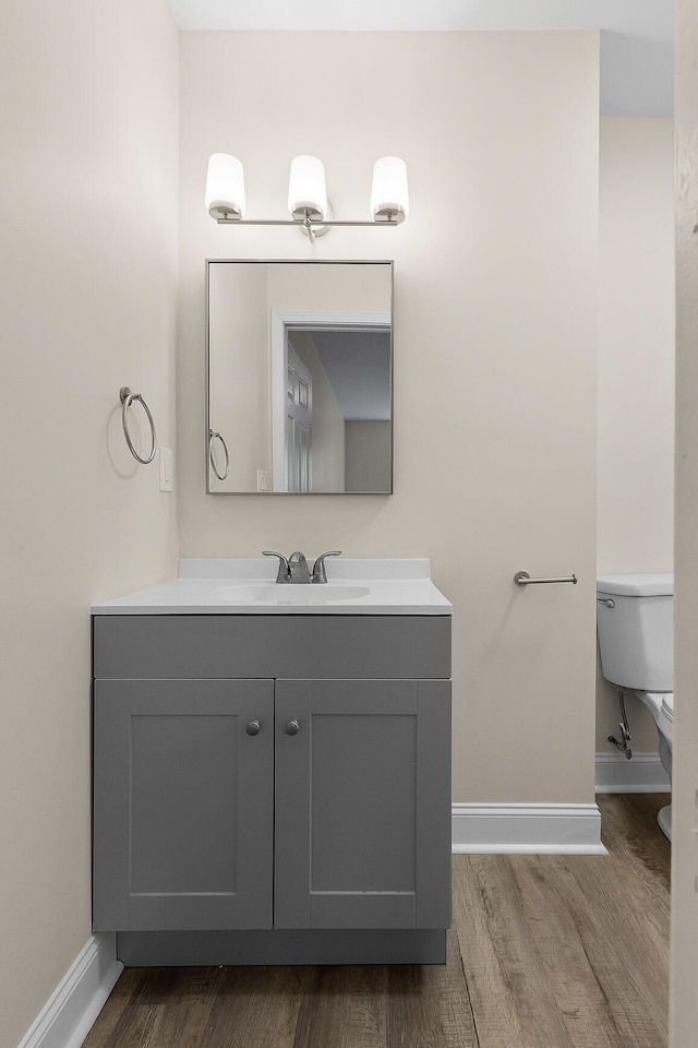 bathroom with vanity, hardwood / wood-style floors, and toilet