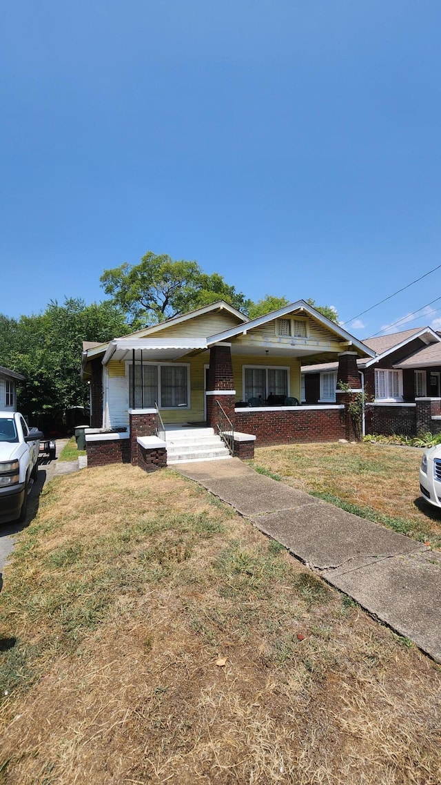 view of front facade with a front yard and covered porch