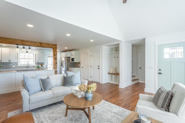 living room featuring lofted ceiling, hardwood / wood-style floors, and sink