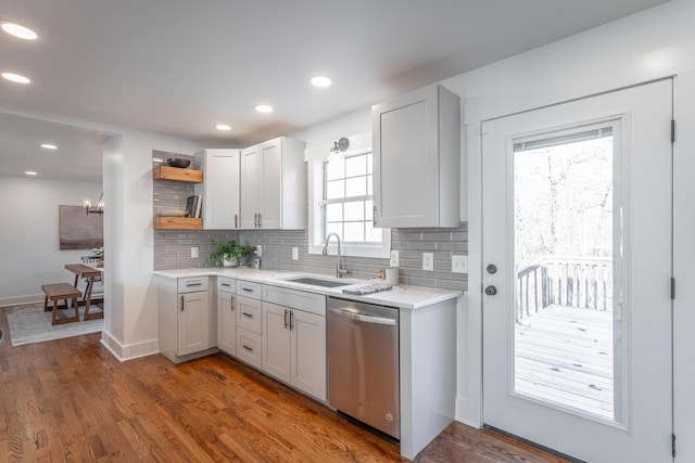 kitchen featuring dark hardwood / wood-style flooring, sink, stainless steel dishwasher, and white cabinets