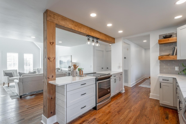 kitchen with tasteful backsplash, wood-type flooring, white cabinets, stainless steel electric stove, and beamed ceiling