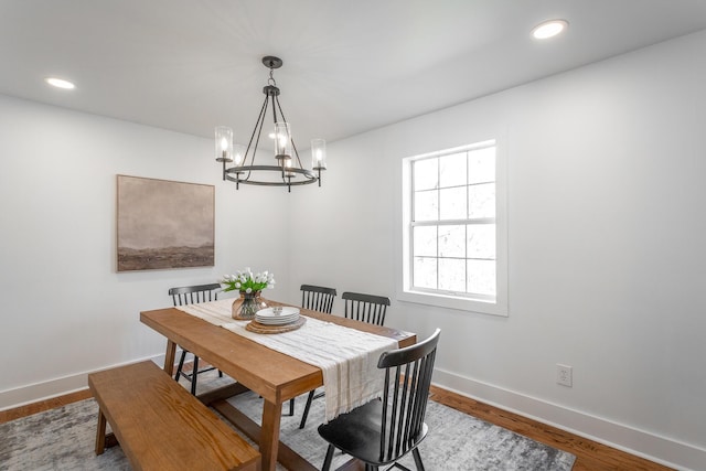 dining area featuring hardwood / wood-style floors and a notable chandelier