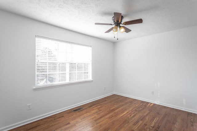 spare room featuring ceiling fan, dark hardwood / wood-style floors, and a textured ceiling