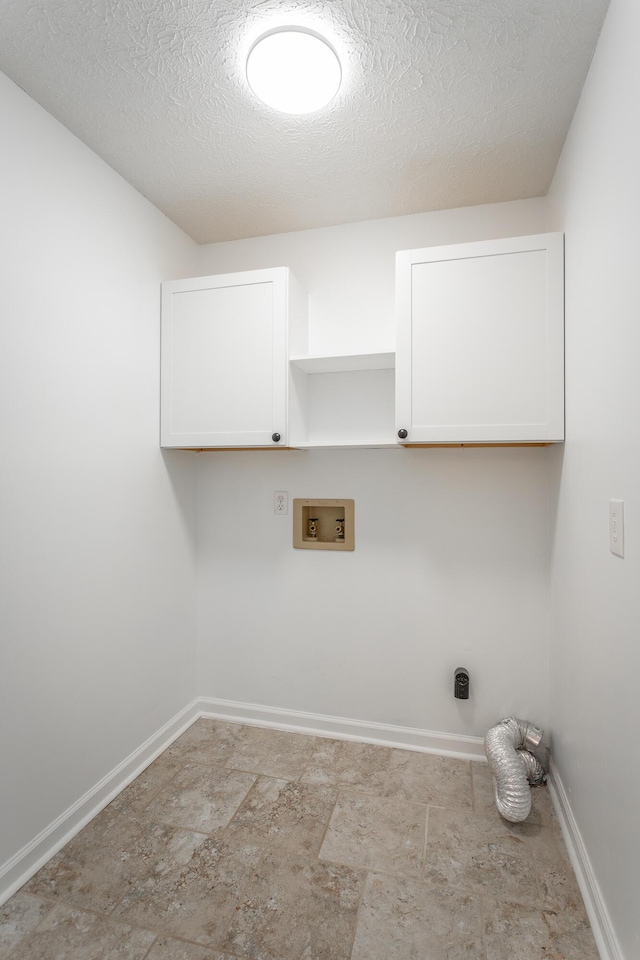 laundry area featuring cabinets, washer hookup, and a textured ceiling