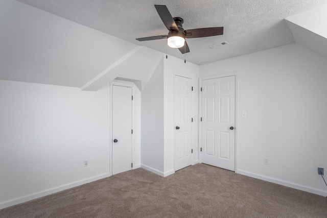 bonus room with vaulted ceiling, carpet, ceiling fan, and a textured ceiling