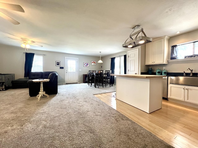 kitchen featuring hanging light fixtures, plenty of natural light, sink, and a center island