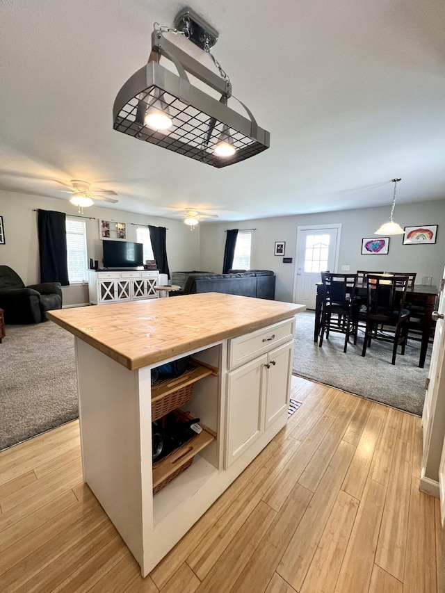 kitchen featuring wood counters, white cabinetry, pendant lighting, and a center island