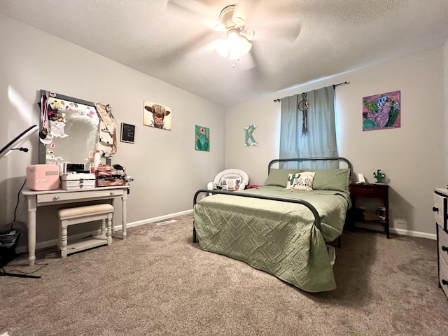 carpeted bedroom featuring ceiling fan and a textured ceiling