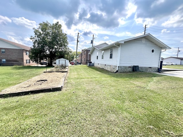 view of side of home with a storage shed and a lawn