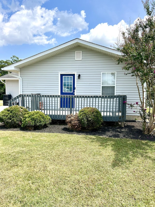 rear view of property featuring a yard and a deck