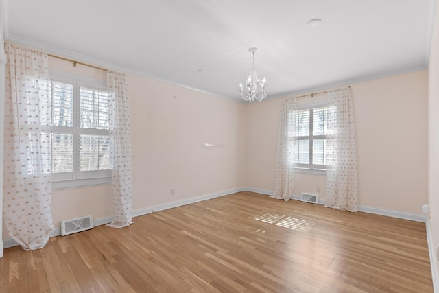 spare room with crown molding, light hardwood / wood-style floors, and a notable chandelier