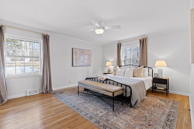 bedroom featuring crown molding, wood-type flooring, and ceiling fan