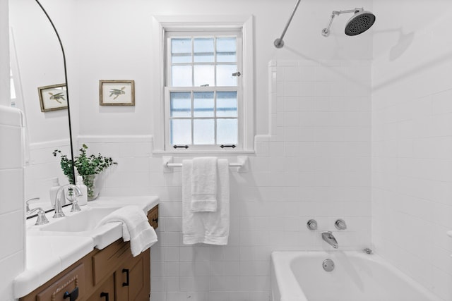 bathroom featuring vanity, tiled shower / bath combo, and tile walls