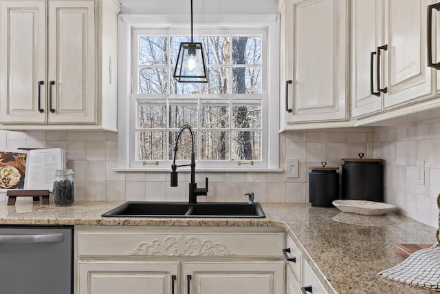 kitchen with sink, tasteful backsplash, white cabinetry, dishwasher, and light stone countertops