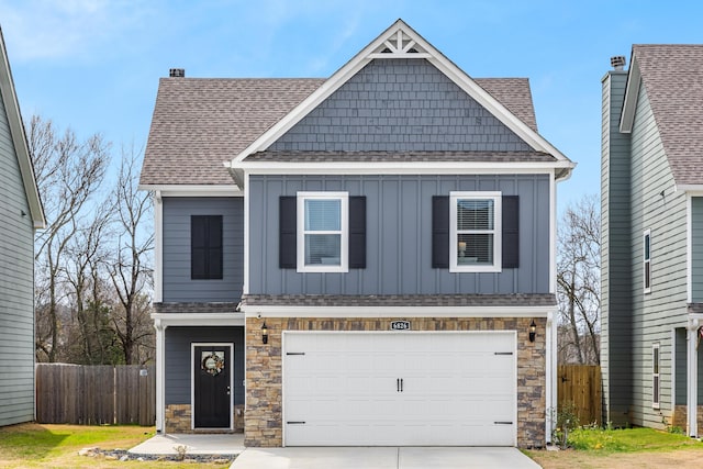 view of front of house featuring board and batten siding, driveway, an attached garage, and fence