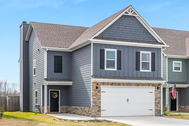 view of front of property featuring concrete driveway, a shingled roof, a chimney, and board and batten siding